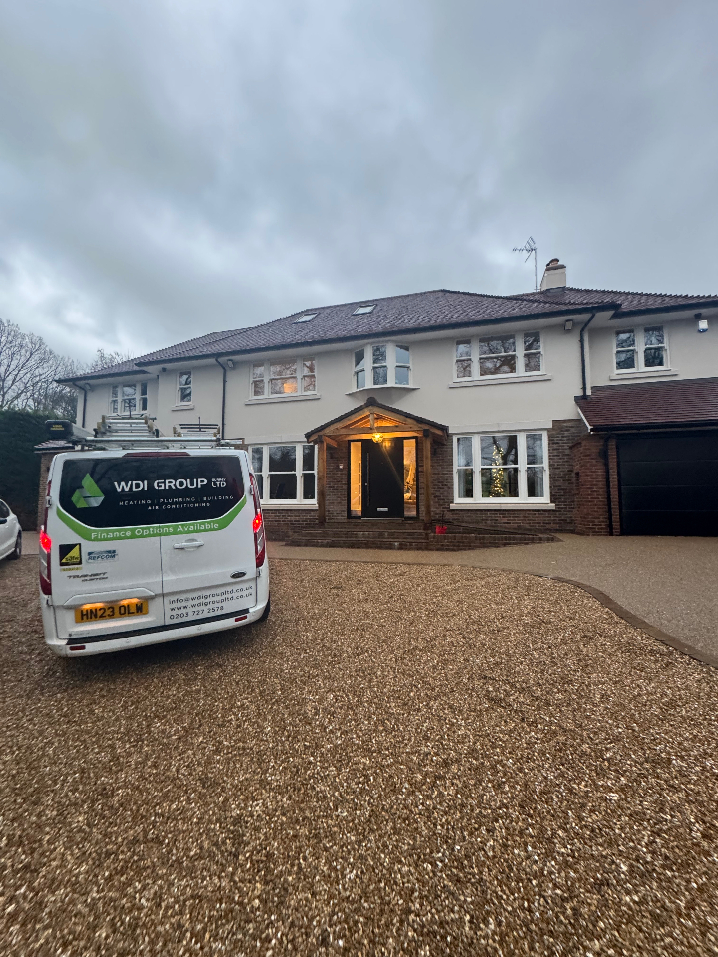 WDI Group (Surrey) Ltd van parked outside a large detached house before an air conditioning installation